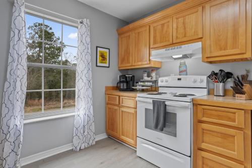 a kitchen with a white stove top oven next to a window at Waterfront Home with Pool, Hot Tub and Game Area in Shoreline Park