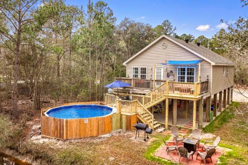 a house with a deck and a swimming pool at Waterfront Home with Pool, Hot Tub and Game Area in Shoreline Park