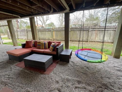 a porch swing with a couch and a dog bed at Waterfront Home with Pool, Hot Tub and Game Area in Shoreline Park