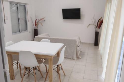 uma sala de jantar branca com uma mesa e cadeiras brancas em Casa en Gualeguaychú em Gualeguaychú