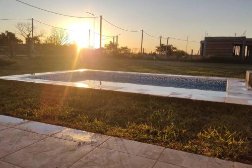 een zwembad in het gras met de zonsondergang op de achtergrond bij Casa en Gualeguaychú in Gualeguaychú