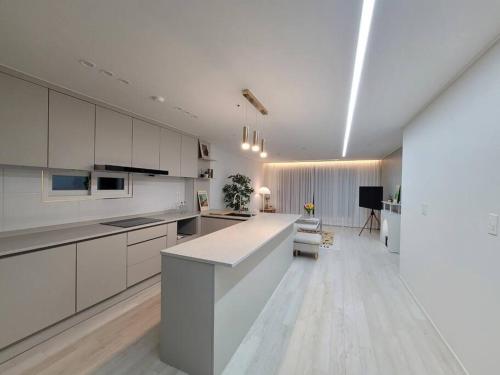 a kitchen with white cabinets and a white counter top at Sosaewool Avenue in Bucheon