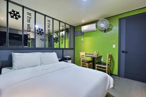 a bedroom with a bed and a desk with a fan at Alps Motel in Incheon