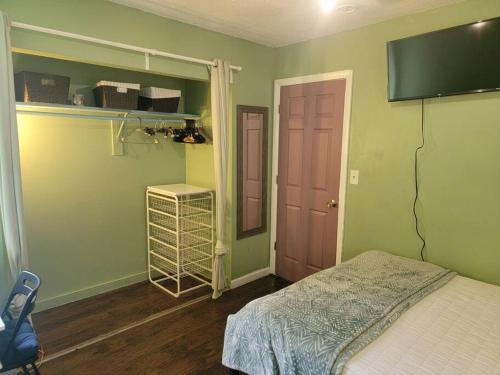 Rock Pad AirBnB في نيو هافن: غرفة نوم مع سرير وتلفزيون على الحائط