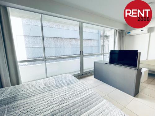 1 dormitorio con 1 cama y TV de pantalla plana en Rent Balcarce en Buenos Aires