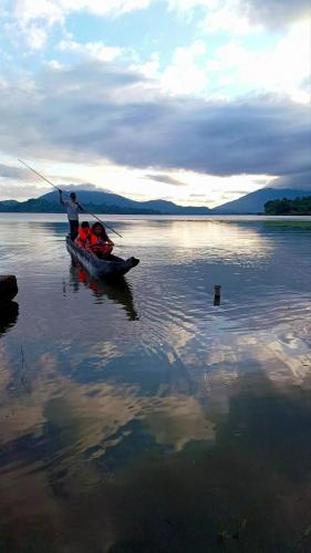 a man fishing in a boat on a lake at Lak View hotel in Lien Son