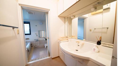 a bathroom with a sink and a mirror at 丘の上の隠れ家邸宅 Villa VIEW in Nanjo