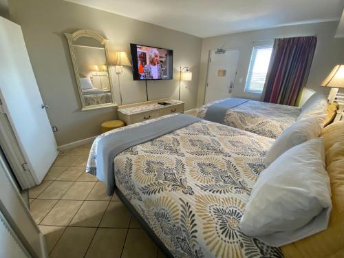 a hotel room with two beds and a mirror at Camelot By The Sea Ocean Front Condo in Myrtle Beach