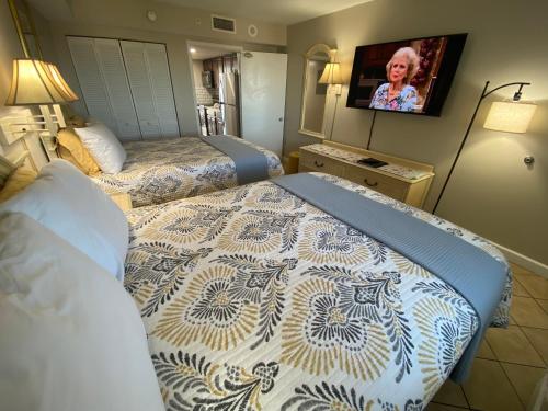 een hotelkamer met 2 bedden en een televisie bij Camelot By The Sea Ocean Front Condo in Myrtle Beach