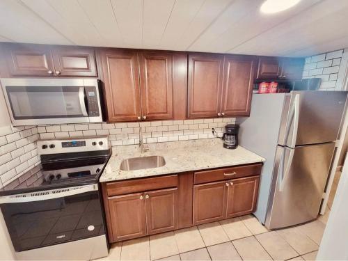 a kitchen with wooden cabinets and stainless steel appliances at Camelot By The Sea Ocean Front Condo in Myrtle Beach