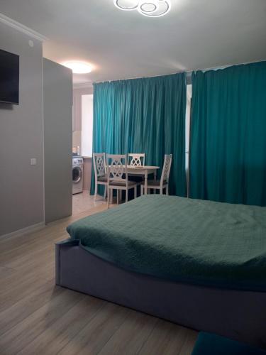 una camera da letto con un letto e un tavolo con sedie di Apartments a Astana