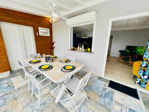 a dining room with a table and chairs at Maison T3 Nid Bleu - Piscine Privée in Le Marin