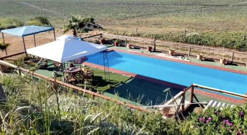 einen Pool mit Sonnenschirm, Tisch und Stühlen in der Unterkunft Cabañas Laguna Seca 