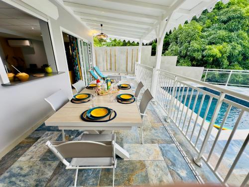 - une table sur le balcon d'une maison dans l'établissement Maison T3 Nid Bleu - Piscine Privée, au Marin