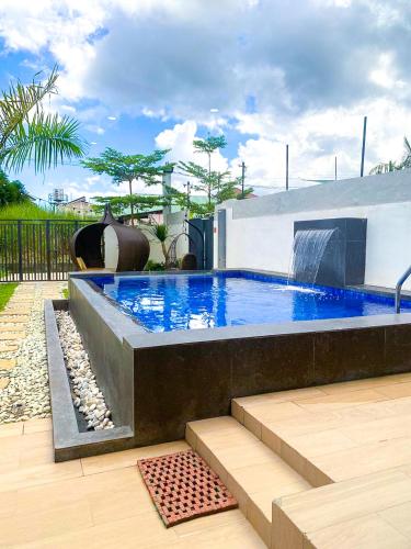a swimming pool with a waterfall in a backyard at Hidden Haven Subic Villa w/ Infinity Pool in Subic