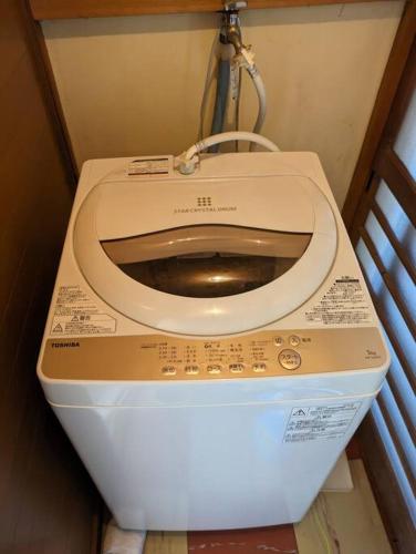 a toilet in a small bathroom with the lid up at 古民家一軒貸切/BBQコンロ・プラレール貸出/無料パーキング　[しずこのいえ] in Tochigi