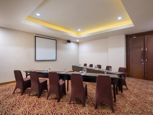 a conference room with a large table and chairs at Hotel Santika Premiere Gubeng Surabaya in Surabaya