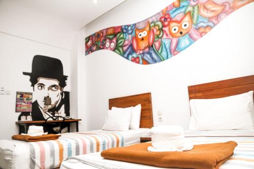 マナドにあるIstanaku Guesthouse 2の壁に絵画が飾られたベッド2台が備わる客室です。