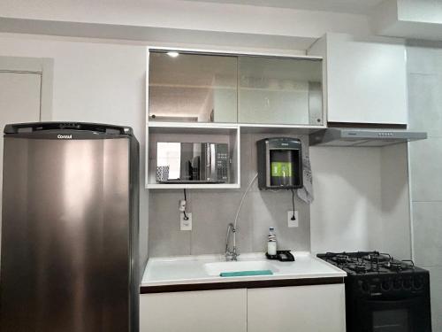 kuchnia z lodówką i kuchenką ze stali nierdzewnej w obiekcie Apto Allianz Metrô Barra Funda w São Paulo