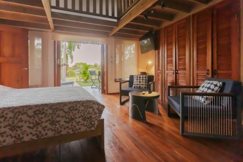 a bedroom with a bed and a table and chairs at Casitas de madera in Punta Chame