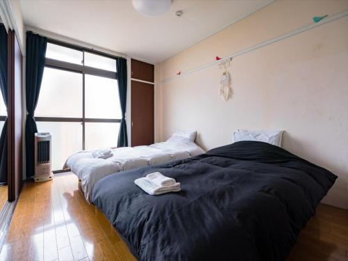 Duas camas num quarto com uma janela em Murata Corpo 301 em Tóquio