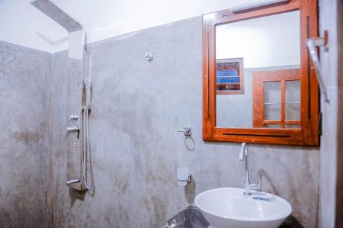 W łazience znajduje się umywalka i lustro. w obiekcie Sweet Emotion w mieście Mirissa