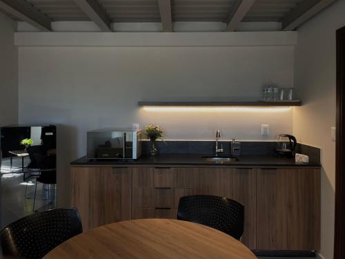 Homa Lofts في كوليما: مطبخ مع حوض وطاولة مع كراسي