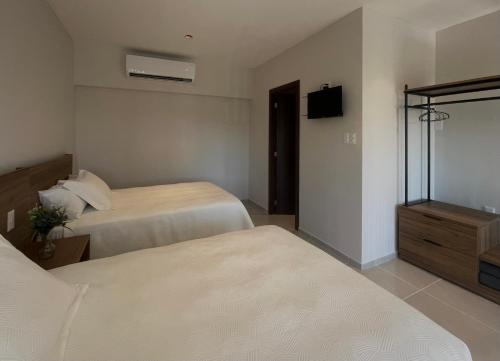 ein Hotelzimmer mit 2 Betten und einem TV in der Unterkunft Homa Lofts in Colima