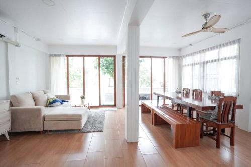 uma sala de estar com um sofá e uma mesa em Whales Come to the River - Riverside - 3 rooms on 2nd floor em Ban Bang Phli Nua