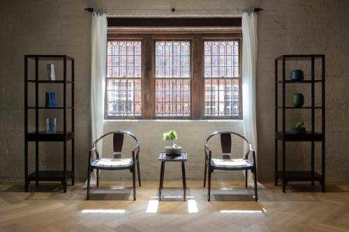 two chairs in a room with a window at In The Brick Spa And Hotel in Melbourne