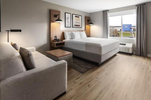 WillistonにあるHawthorn Extended Stay by Wyndham Williston Burlingtonのベッドとソファ付きのホテルルーム