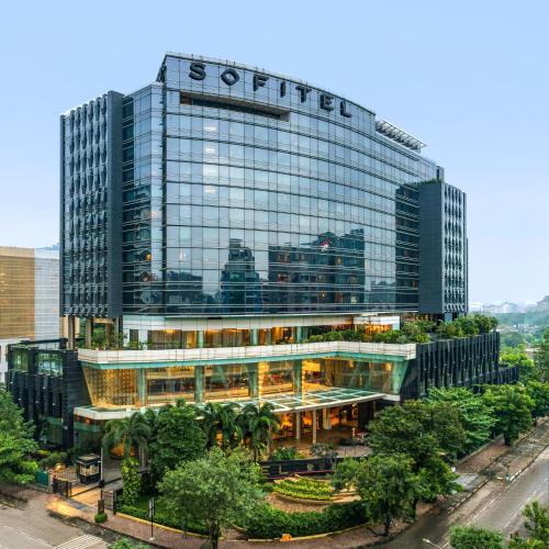 a large glass building with a sign on it at Sofitel Mumbai BKC in Mumbai