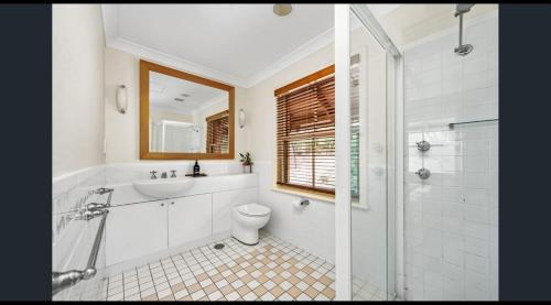 a bathroom with a toilet and a sink and a shower at Villa 2br Shiraz Villa located within Cypress Lakes Resort in Pokolbin