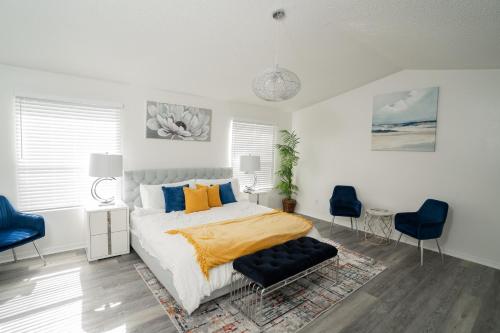 a bedroom with a bed and two blue chairs at Magical Vacation Stay in Davenport