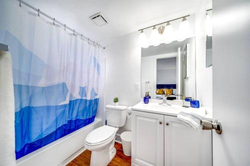 a white bathroom with a toilet and a sink at King Water View - No Extra Fees - Palm Wave Says in Coconut Creek