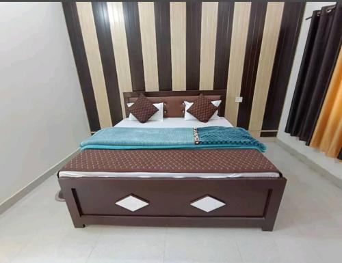 a bed with a wooden headboard in a room at Ramam hotel by Naavagat Ayodhya in Ayodhya