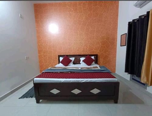 a bedroom with a bed in a room with orange walls at Ramam hotel by Naavagat Ayodhya in Ayodhya