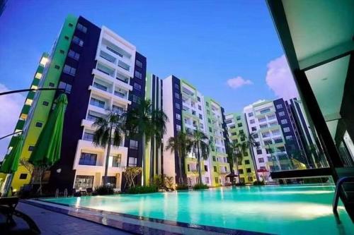 a swimming pool in front of some tall buildings at One Life Four Season Waterpark Guest House Manhattan Condominium in Ipoh