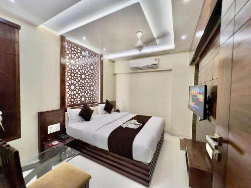 sypialnia z łóżkiem i telewizorem w pokoju w obiekcie HOTEL REST INN w mieście Surat