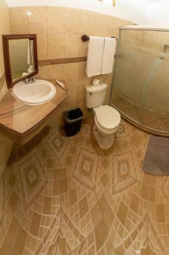 a bathroom with a sink and a toilet and a mirror at CABAÑAS THAJU in El Naranjito