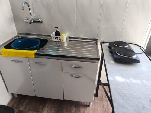 eine kleine Küche mit einer Spüle und einem Herd in der Unterkunft Alojamiento Donatello in Durazno