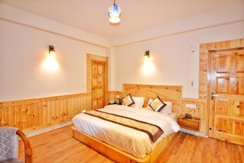 - une chambre dotée d'un grand lit avec des boiseries dans l'établissement Hilly Bee, Manali, à Manali