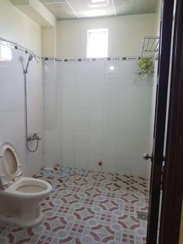 a bathroom with a toilet and a shower at Hostel Đặng Lợi ホステルダンロイ in Chau Doc