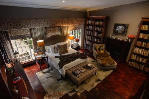 a bedroom with a bed and a couch and a chair at The Great Gatsby Houghton in Johannesburg