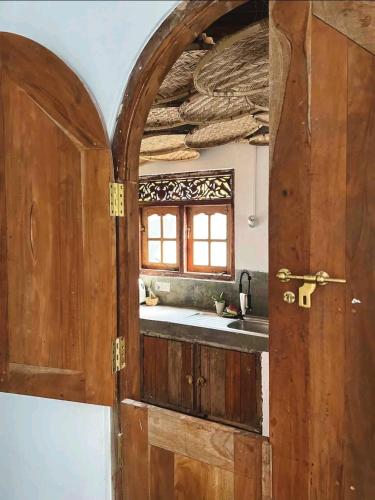 una puerta abierta a una cocina con fregadero en Villa AMMA 2 quartos c/Jacuzzi, en Ahangama