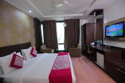 Cette chambre comprend un lit et une télévision à écran plat. dans l'établissement Hotel Panickers Residency - Ajmal Khan Market Karol Bagh, à New Delhi