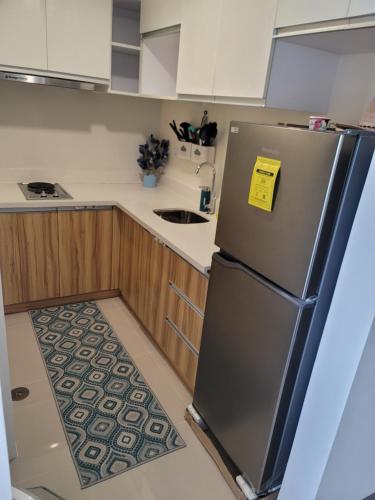 a kitchen with a refrigerator with a yellow tag on it at Newcoast Boracay Top Floor View in Boracay