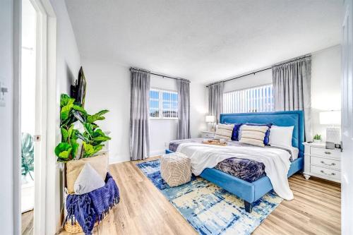 a bedroom with a blue bed with a blue headboard at Chic and Central Condo - Palm Wave Says in Coconut Creek
