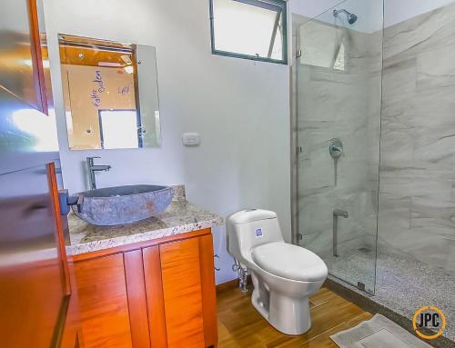 y baño con lavabo, aseo y ducha. en Modern Mountain View Home by Nauyaca Waterfall, en Platanillo