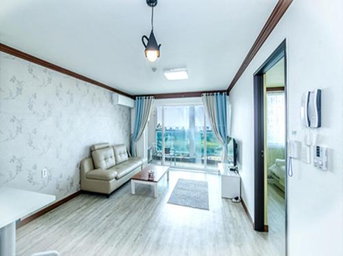 sala de estar con sofá y ventana grande en Ghost House en Jeju